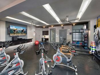 a gym with exercise equipment and a flat screen tv at The Rialto, Florida, 32819